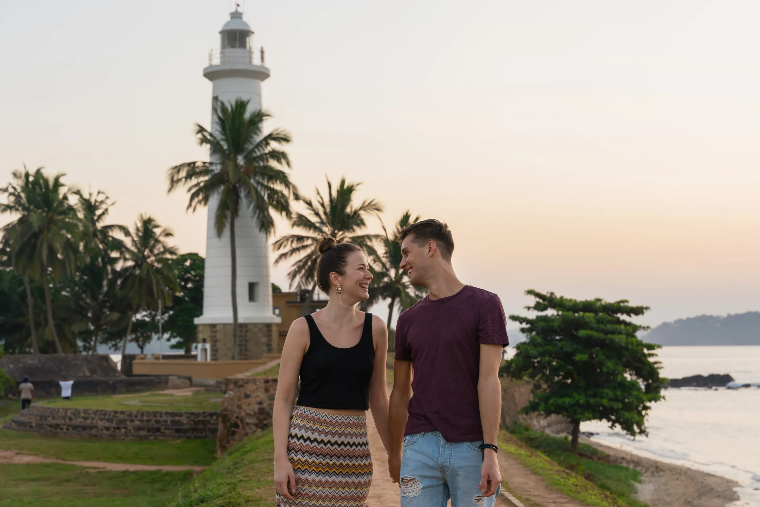 Young,Couple,Walking,Near,The,Sea,On,Sunset